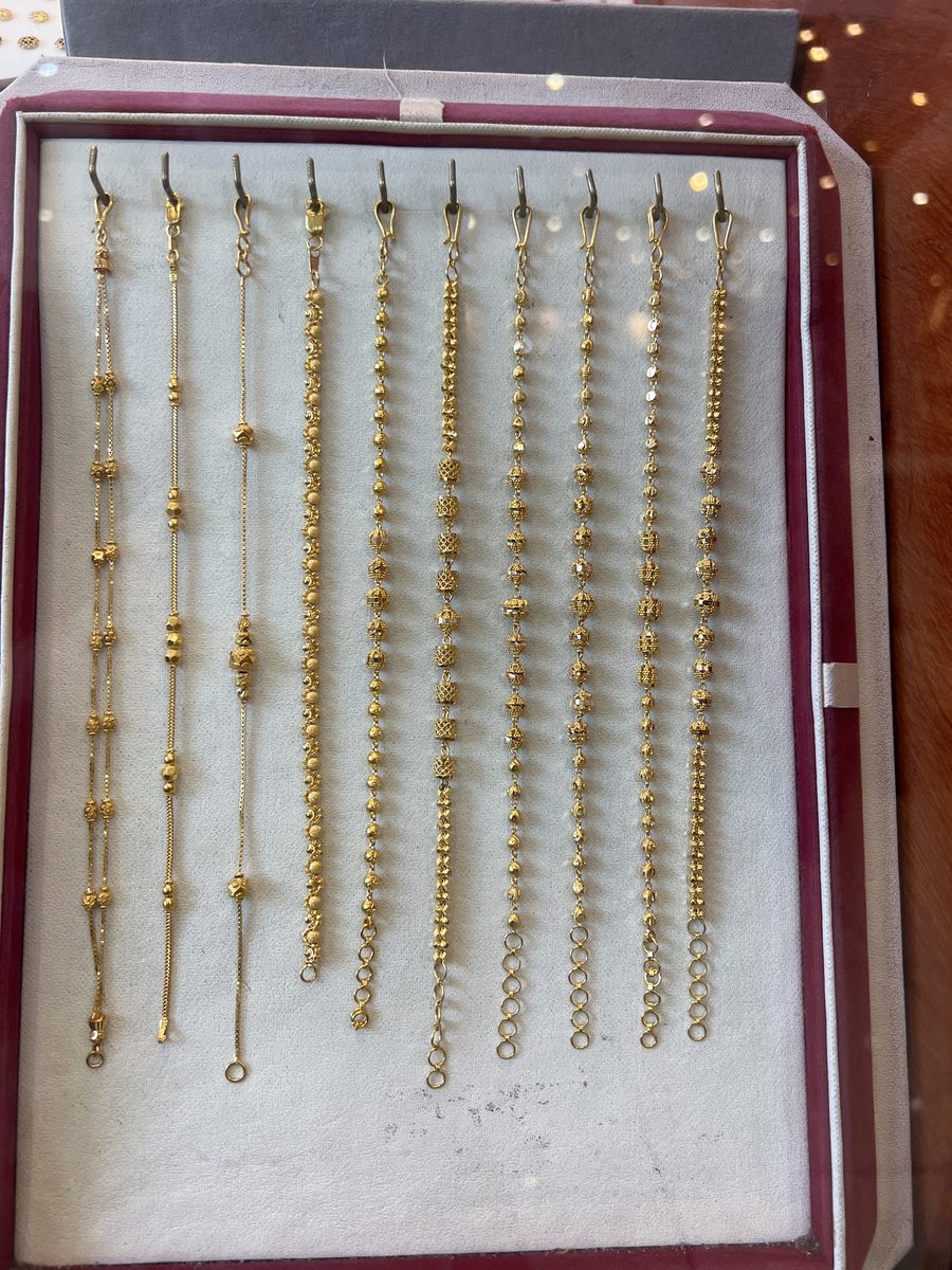 A tray of patterned 22ct gold bracelets on burgundy velvet, Kowaj Jewellers