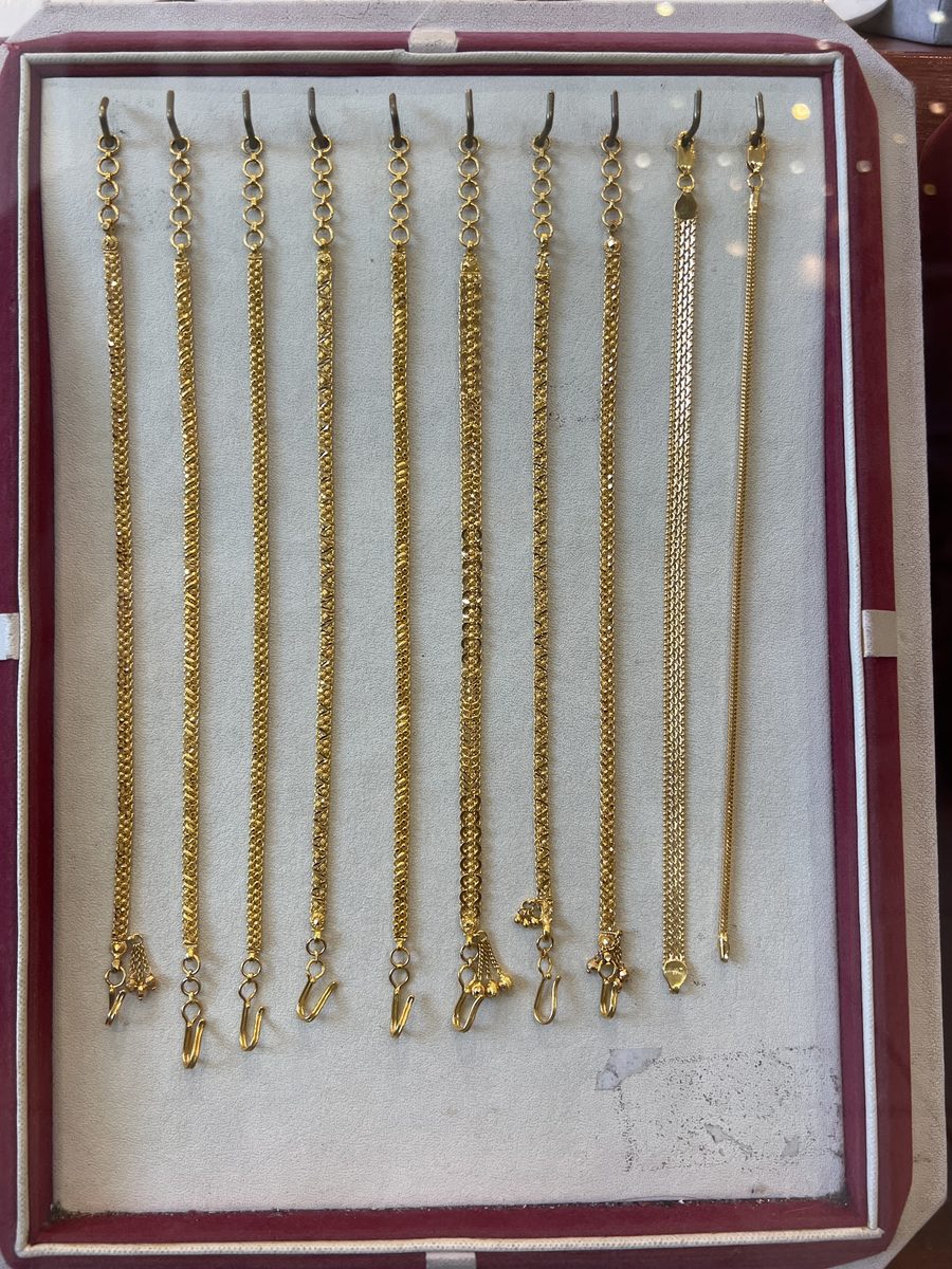 A tray of 22ct gold bead bracelets with drop charms, Kowaj Jewellers